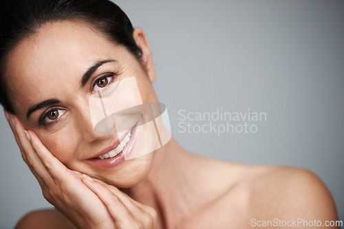 Image of Woman, studio and smile with hand, skin and care for treatment and proud. Model, cosmetics and natural with lip gloss, glow or aesthetic for antiaging confidence portrait isolated on grey background