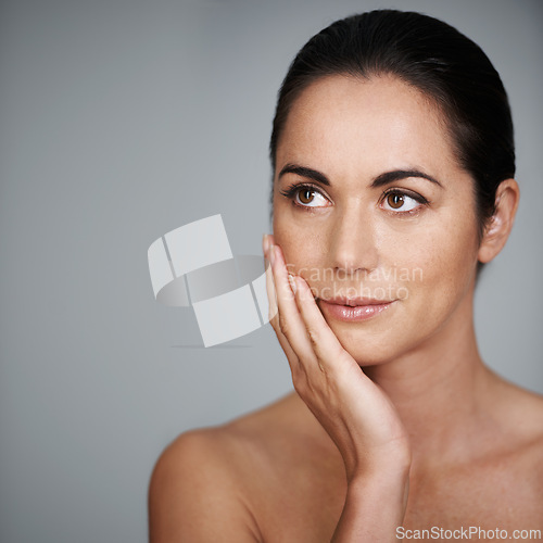 Image of Beauty, skincare and woman touching face in makeup at studio isolated on a gray background mockup. Cosmetics, hand and model in facial treatment for dermatology, thinking and health for anti aging