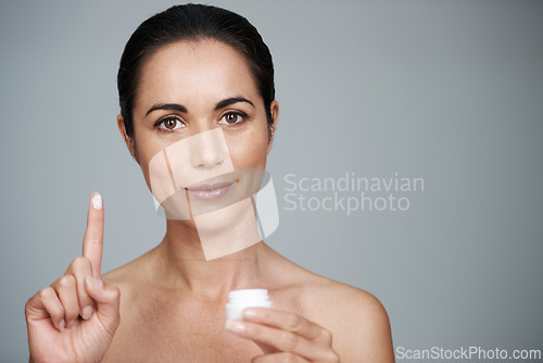 Image of Portrait, mature and woman with cream for skincare in studio isolated on gray background mockup. Face, cosmetics or model with moisturizer container for dermatology, beauty or hydration for antiaging