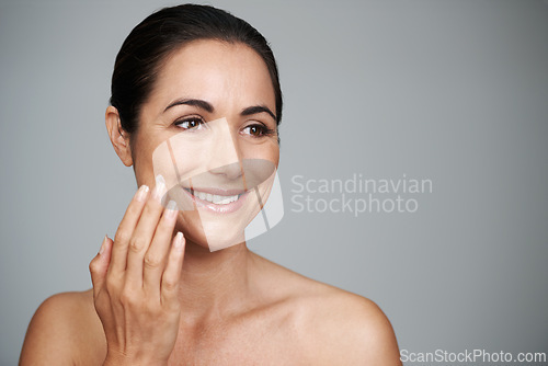 Image of Face cream, beauty and mature woman in studio for skincare, natural and face treatment. Smile, cosmetic and female person with spf, lotion or sunscreen for dermatology routine by gray background.