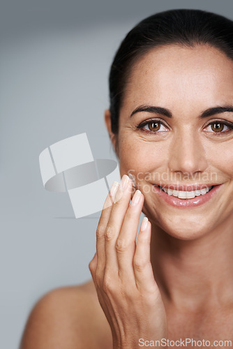 Image of Smile, face cream and portrait of woman in studio with beauty, natural and anti aging routine. Happy, cosmetic and mature person with spf, lotion or sunscreen for dermatology by gray background.