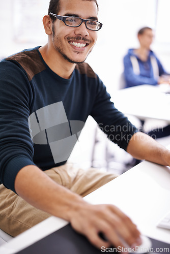 Image of Happy man, portrait and glasses with computer for research and development in creative startup at office. Handsome male person, nerd or geek working on desktop PC for design or project at workplace