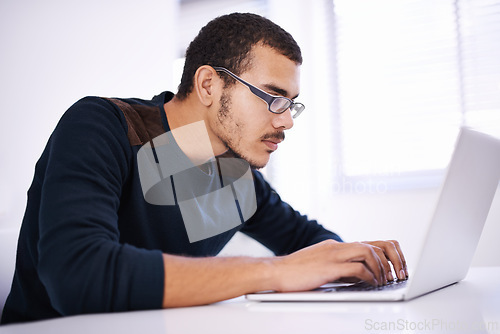 Image of University, desk and man with laptop for research, study or elearning with education, knowledge and opportunity. Computer, reading and college student writing report for online course with glasses.