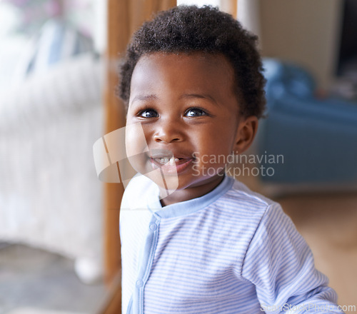 Image of Baby, smile or teeth in childcare, health or growth in play, leisure and relaxation in living room. Happy, black boy or child as curious, playful or fun in motor skill or childhood development