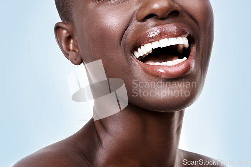 Image of Mouth of woman, happy or laughing with beauty, cosmetics or healthy skin for shine isolated in studio. Face, closeup or funny girl model with lip gloss, smile or skincare results on blue background