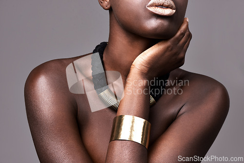 Image of Woman, fashion and jewerly with makeup in studio for aesthetic with glowing skin, lipstick and necklace. African beauty, person and cosmetics with bangle, glamour and skincare on grey background