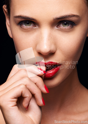 Image of Beauty, makeup and portrait of woman for skincare in studio with manicure on hand isolated on a black background. Cosmetics, model and face of person with red lipstick on mouth, serious or bite thumb