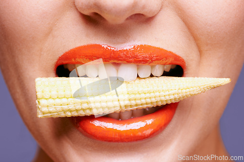 Image of Woman, lipstick and vegetable in mouth for beauty, nutrition and healthy with vegan cosmetic product in studio. Cruelty free makeup, cosmetology and baby corn, orange lip gloss for aesthetic or art