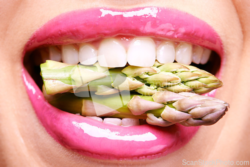 Image of Woman, lipstick and closeup of vegetables in mouth for beauty, nutrition and healthy with vegan cosmetic product. Cruelty free makeup, cosmetology and asparagus, pink lip gloss for aesthetic or art