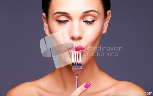 Image of Woman, studio and fork with makeup, skin and beauty for creative diet. Model, closeup and face with lipstick, lip gloss and aesthetic for glamour and health or wellness with silverware and bliss
