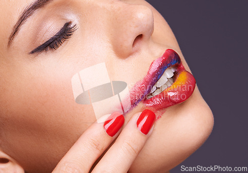 Image of Lipstick, smear and woman with makeup and hand, beauty and red nail polish with cosmetic product in studio. Face, smudge on skin and color for cosmetology with manicure and art on purple background
