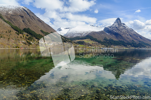 Image of Pristine reflections on the crystal-clear sea amidst snow-capped