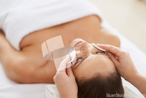 Image of Woman, cotton and facial massage for treatment to relax, cosmetics and beauty therapy for skin care. Female person, calm and serene or dermatology, closeup and pampering at hotel and peace or zen