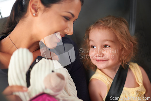 Image of Taxi, love or mother and daughter in a car for adventure, road trip or bonding with teddy bear games. Happy, family and kid with mom in a backseat of cab with care, trust and safety, travel or fun