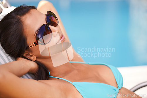 Image of Woman, bikini or tanning at swimming pool to relax, rest or chill in summer holiday vacation in Hawaii. Calm girl, break and zen female person sunbathing in a spa at resort, home or hotel for peace
