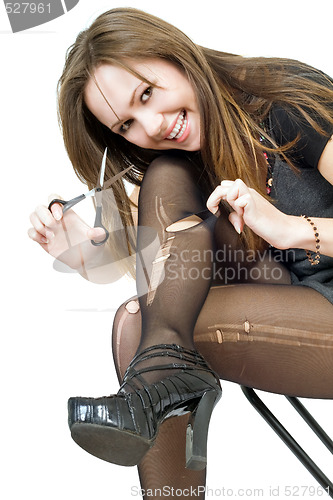 Image of Smiling girl with scissors cuts the stockings. Isolated