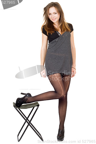 Image of Young woman in the torn stockings and a chair