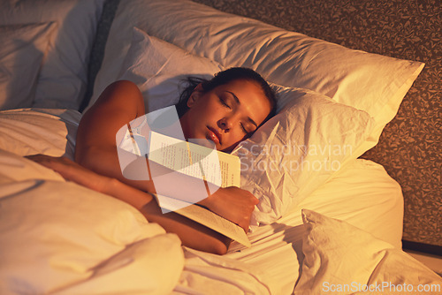 Image of Woman, sleep and book in room and light, dreaming female person or night lamp for story and novel. Relax, hobby and tired girl with fantasy or biography, literature or learning for peaceful rest