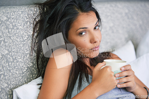 Image of Woman, portrait and tired or drinking coffee in bed for early morning in apartment or exhausted, caffeine or house. Female person, face and latte beverage on Monday for unhappy, moody or insomnia