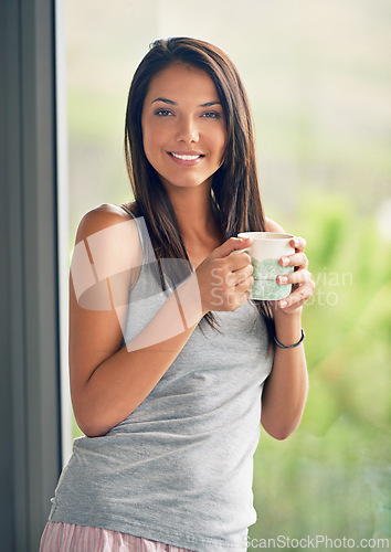 Image of Woman, portrait and drinking coffee at window view with smile in apartment for holiday, weekend or vacation. Female person, face and caffeine beverage in London or calm in bedroom, resting or pyjamas