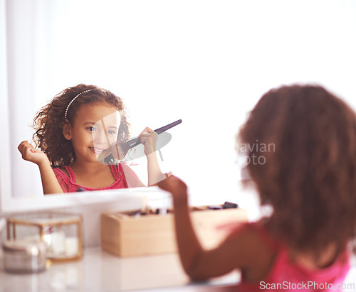 Image of Child, brush and mirror with makeup for skincare, beauty or happiness with cosmetics or smile. Girl, grooming and reflection of a young kid in with foundation, space or blusher in the home or house