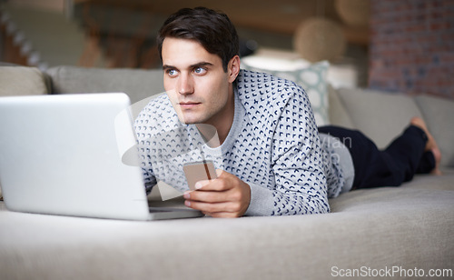 Image of Man, laptop and smartphone at home on sofa for remote work as freelance, journalist and online research for newspaper. Male person, living room and focus on internet with information for article.