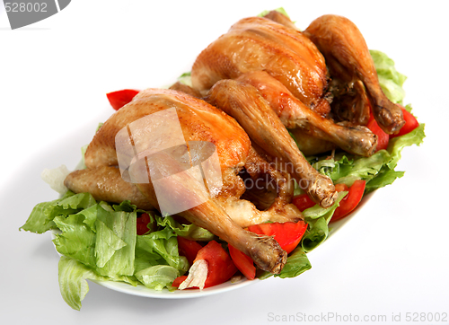 Image of Two roast chickens on a bed of salad