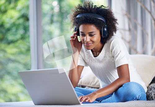 Image of Black woman, headphones and laptop at home for online teaching, e learning and education in living room. Female person, scholar and university student in house for remote class, studying and tuition