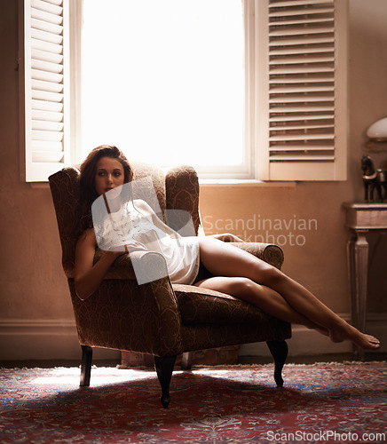 Image of Woman, sexy and thinking in chair at home, relax and underwear for elegant calm female person. Confident, feminine or sensual comfort, fashion and lady by window in lounge with natural light