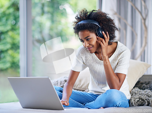 Image of Headphones, university student and laptop at home for online education, e learning and teaching in living room. Female person, computer and black woman in house for remote class, studying or tuition