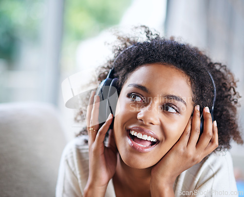 Image of Headphones, smile and happy woman person on couch, living room and listening to music. Happy, joyful or thinking while streaming audio, podcast or radio for entertainment for African female listener