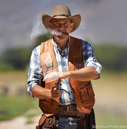 Image of Cowboy, portrait and aim gun to shoot for standoff or gunfight in duel for wild western culture in Texas. Male gunslinger or outlaw, revolver and confrontation for defense or conflict with battle