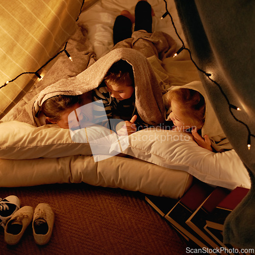 Image of Children, happy and sleepover in tent at night with conversation, bonding and holiday adventure or vacation. Young friends or kids by fairy lights, pillows and blanket at home for fun storytelling