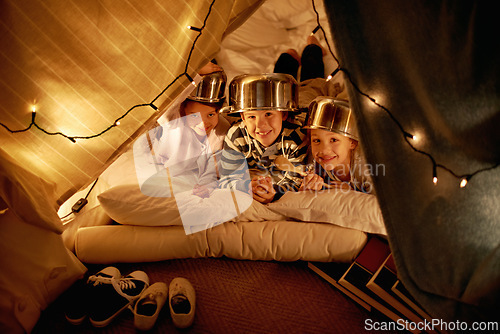 Image of Kids, portrait and siblings with pot helmet in a fort for fantasy, learning or playing in their home. Happy family, face and children on a floor with tent games, development or smile in a house