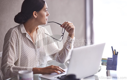 Image of Businesswomen, thinking and glasses at office, desk and laptop for corporate worker. Technology, computer or contemplating for female accountant, online and working on budget and finance research