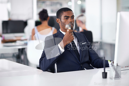 Image of Black man, smoking and vaping in office or business with cigarette, electronic pipe in formal clothes. Businessman, corporate and working on computer, technology or connect and salesman in workplace