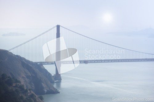 Image of Golden Gate bridge, fog and ocean at sunrise by road, infrastructure or architecture in nature. Street, highway and hill with rocks, sea or horizon in morning sunshine for transport in San Francisco
