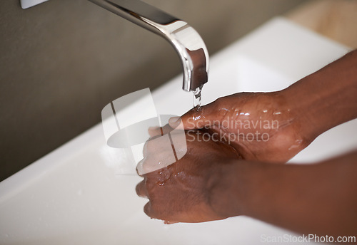 Image of Sink, water and washing of hands for hygiene, bacteria and cleaning virus for healthcare. African person, self care and sanitary with bath with liquid in washbasin of bathroom for safety from germs