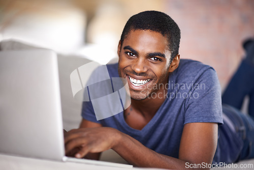 Image of Man, portrait and smile on sofa with laptop for internet streaming, communication or online games in home. Student, african person and happy with face, relax or technology in living room for research