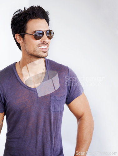 Image of Happy, man and fashion with sunglasses on wall outdoor with confidence, cool style and pride. Summer, holiday and person smile in casual outfit for vacation, break and relax on white background