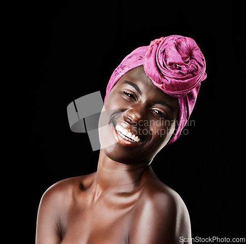 Image of Black woman, head wrap and beauty portrait with smile, skincare and natural cosmetics in studio. Traditional, turban and African fashion with wellness and skin glow with makeup and dark background