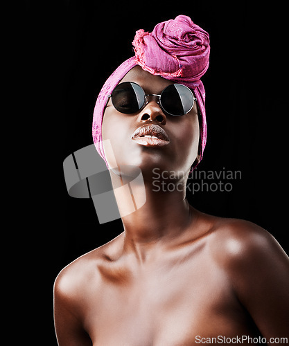 Image of Face, fashion and culture with black woman in studio isolated on dark background for heritage. African, model and sunglasses with confident young person in trendy headwear for traditional style