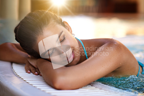 Image of Calm woman, relax and lying with water in jacuzzi for holiday, getaway or stress relief at hotel, resort or spa. Face of happy and young female person with smile in hot tub or warm pool on vacation