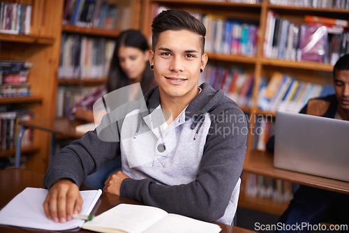 Image of Young man, portrait or studying in library for test or scholarship on campus for class assignment. University student, face or happy for education or research in books for exam preparation by desk