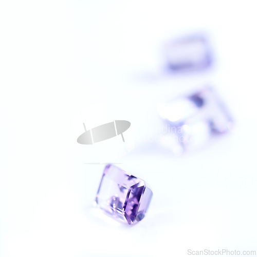 Image of Amethyst, rocks or stone in studio by white background for natural resource, jewelry and baguette for luxury. Gemstone, purple crystal and closeup with shine, glow and brilliant cut for collection