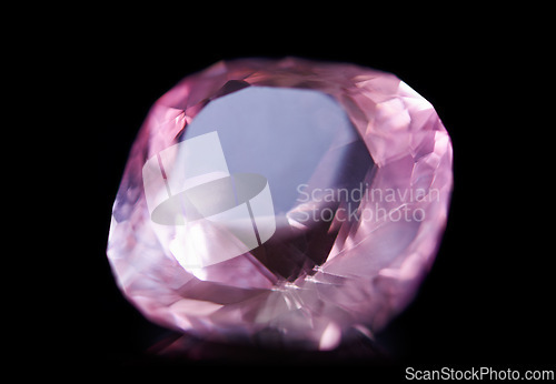 Image of Pink diamond, jewel and stone by black background for natural resource, sparkle and luxury. Rocks, mineral and crystal in closeup for gem with shine, glow and brilliant cut with reflection in studio