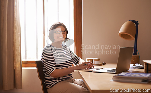 Image of Portrait, businesswoman and positive in home office with confidence, laptop and freelancer with notes for project. Face, entrepreneur and smile for wellness and online research in startup company