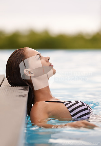 Image of Woman, thinking and relax in swimming pool on luxury holiday or vacation at hotel or villa in Cancun. Person, outdoor or enjoy calm water at resort in Mexico or girl in bikini or swimsuit with peace