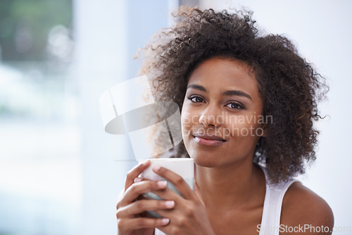 Image of Black woman, portrait and afro with coffee for morning, breakfast or hot beverage by window at home. Face of African female person with smile or caffeine for drink, latte or cappuccino at the house