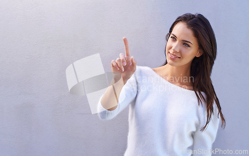 Image of Fashion, smile and pointing for happy woman, advertising and mockup space on studio background. Product, placement and gesture to marketing or sales, promotion or announcement by female model